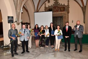 zdjęcie grupowe z prezydentem Wrocławia. W rękach ludzie trzymają kwiatek