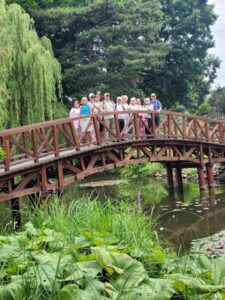 grupa ludzi na mostku wśród zieleni ogrodu botanicznego