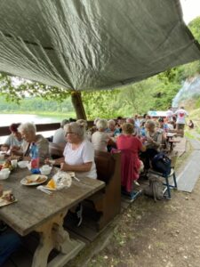 widok na ludzi siedzących przy stołach podczas pikniku