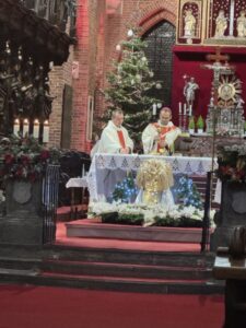 Zdjęcie wewnątrz kościoła, widok na ołtarz przy którym odprawia msze 2 księży