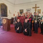 zdjęcie grupowe członków Koła Jelenia Góra wraz z duchownymi wewnątrz pomieszczenia